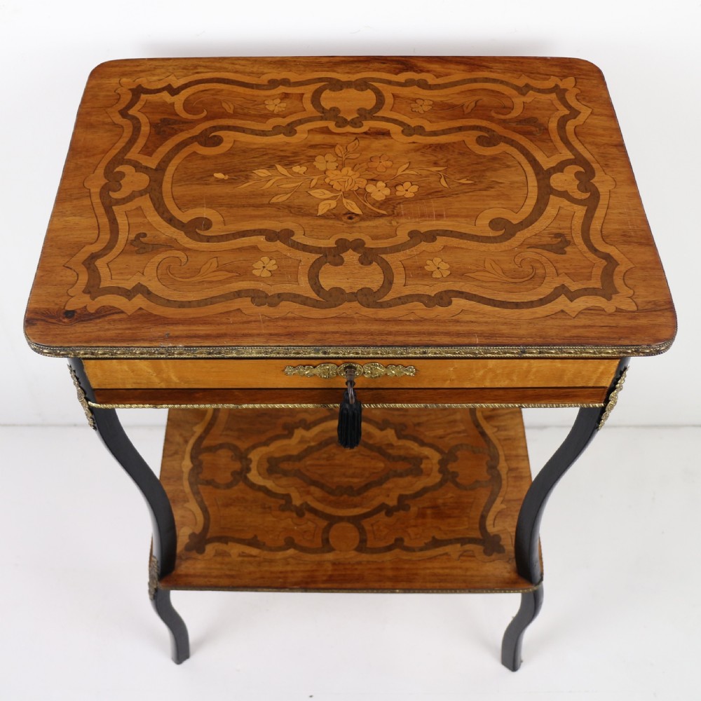 A late 19th-century French Napoleon III work table featuring floral marquetry inlays, ebonised legs, a single lockable drawer, and a lower shelf with brass mouldings. View V