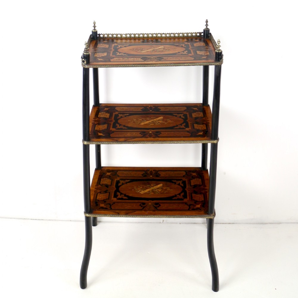 A pair of 19th-century French three-tier etageres featuring inlaid wood marquetry designs, ebonised legs, and pierced brass galleries on top. View X