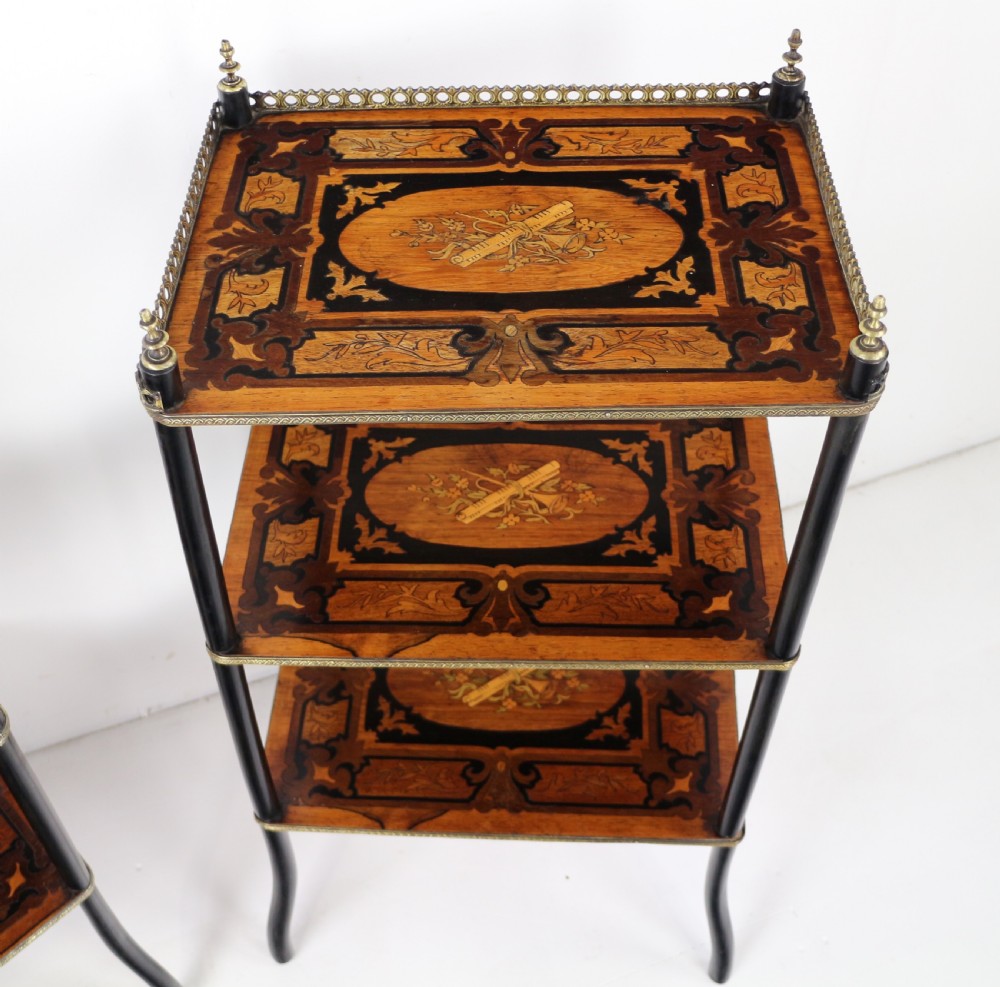 A pair of 19th-century French three-tier etageres featuring inlaid wood marquetry designs, ebonised legs, and pierced brass galleries on top. View XIX