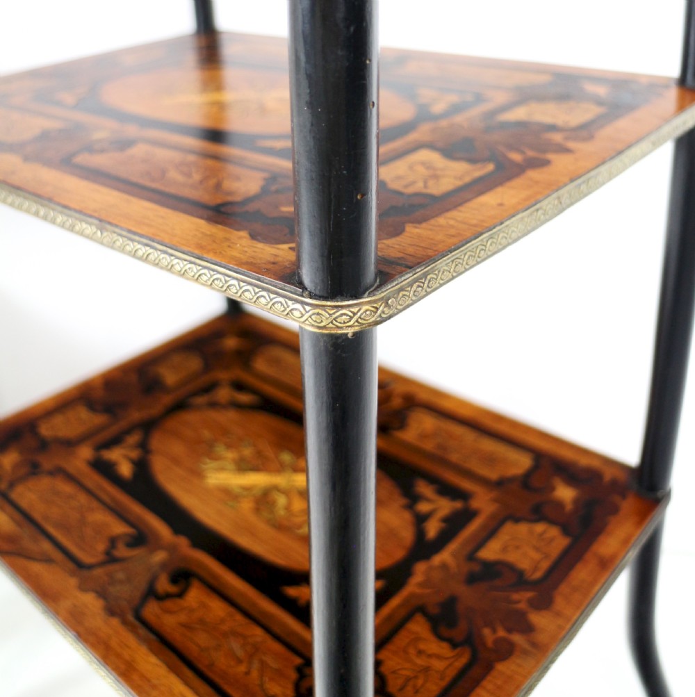 A pair of 19th-century French three-tier etageres featuring inlaid wood marquetry designs, ebonised legs, and pierced brass galleries on top. View XXVII