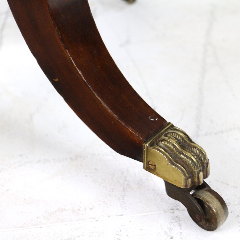 An Irish Regency drop-leaf work table featuring burr yew veneer, a single drawer, a yellow pleated fabric work well, and a quadruped pedestal base with brass castors. View XIV