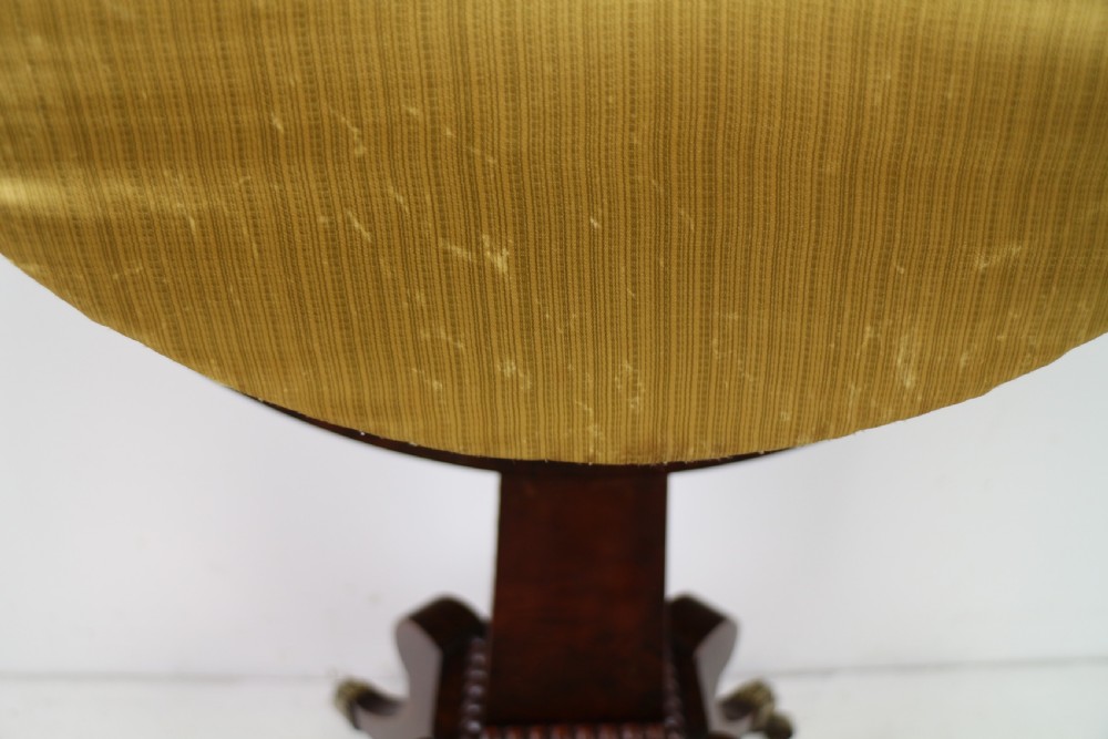 An Irish Regency drop-leaf work table featuring burr yew veneer, a single drawer, a yellow pleated fabric work well, and a quadruped pedestal base with brass castors. View XX