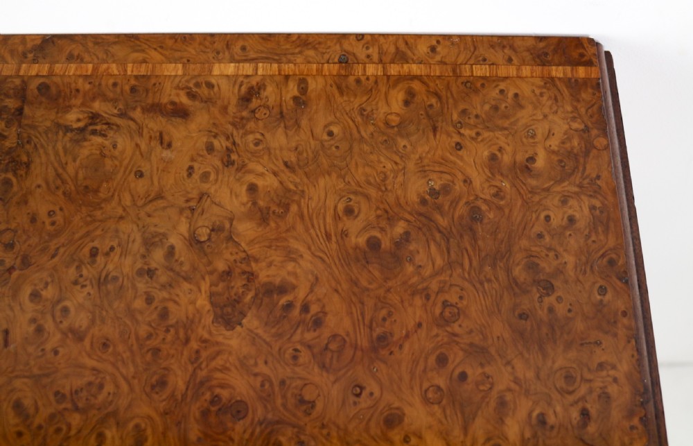 An Irish Regency drop-leaf work table featuring burr yew veneer, a single drawer, a yellow pleated fabric work well, and a quadruped pedestal base with brass castors. View XXV