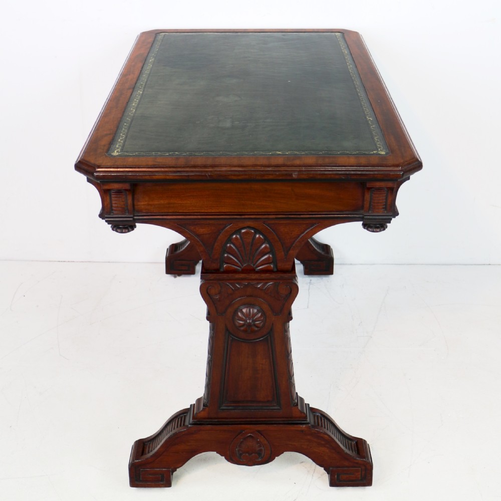 A Late Regency Neoclassical dark mahogany library table featuring a green leather inset writing surface, carved end supports with anthemion motifs, and frieze drawers with keys. View VIII