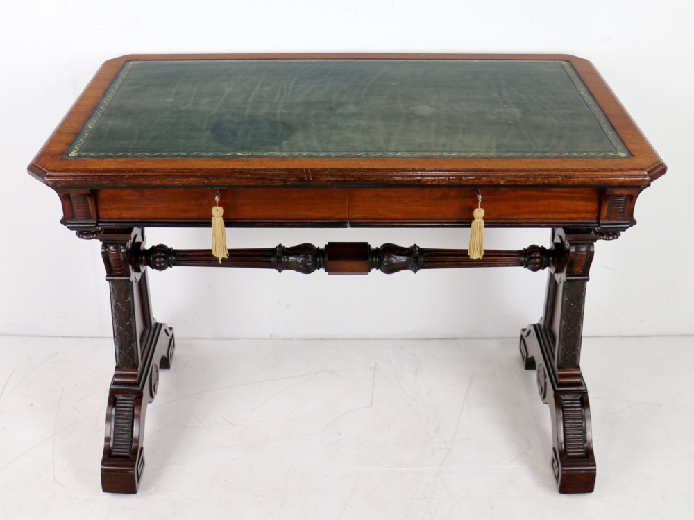 A Late Regency Neoclassical dark mahogany library table featuring a green leather inset writing surface, carved end supports with anthemion motifs, and frieze drawers with keys. View XI