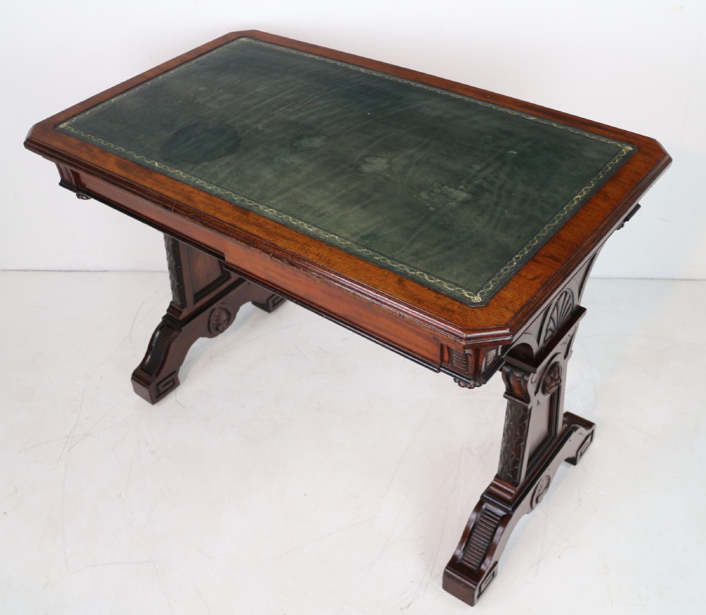 A Late Regency Neoclassical dark mahogany library table featuring a green leather inset writing surface, carved end supports with anthemion motifs, and frieze drawers with keys. View XVI