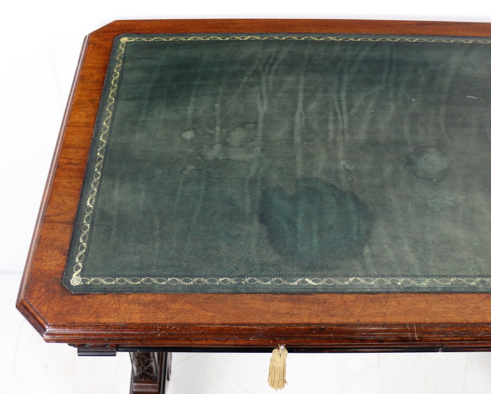 A Late Regency Neoclassical dark mahogany library table featuring a green leather inset writing surface, carved end supports with anthemion motifs, and frieze drawers with keys. View XVIII