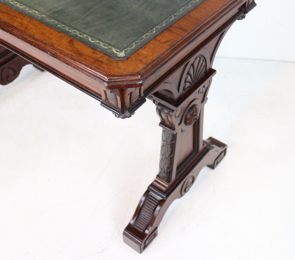 A Late Regency Neoclassical dark mahogany library table featuring a green leather inset writing surface, carved end supports with anthemion motifs, and frieze drawers with keys. View XXI