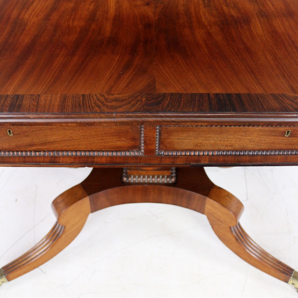 A Regency mahogany drop-leaf sofa table with frieze drawers, turned pedestal, reeded quadrupod legs, and brass castors. View XVIII
