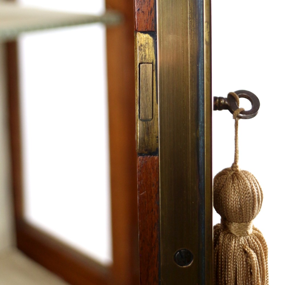 An antique mahogany writing desk cabinet featuring an upper glass cabinet with diamond glazing bars, a curved slatted tambour shutter section, and two drawers on square tapered legs. View XXV