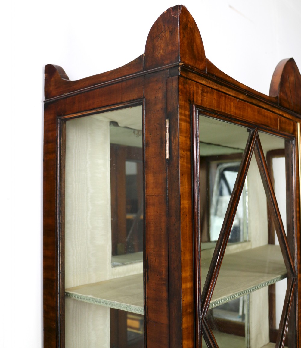 An antique mahogany writing desk cabinet featuring an upper glass cabinet with diamond glazing bars, a curved slatted tambour shutter section, and two drawers on square tapered legs. View XXVI