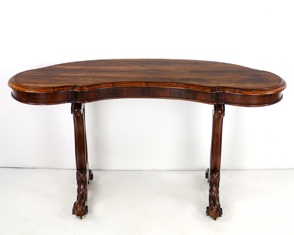 A Victorian rosewood kidney-shaped writing table with a figured timber top supported by carved lyre legs ending in scroll feet. View III