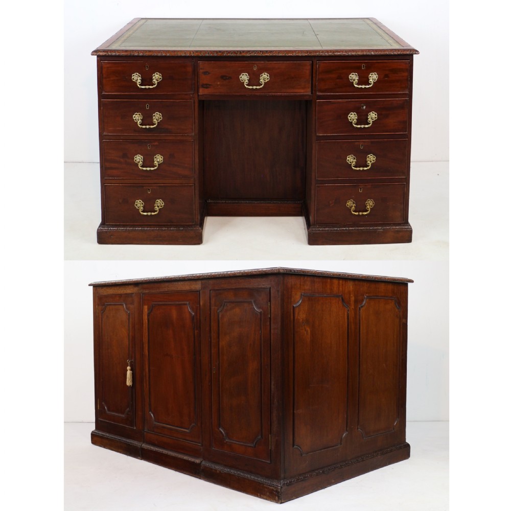 A dark mahogany kneehole library desk featuring multiple drawers with brass drop handles and panelled sides. View V