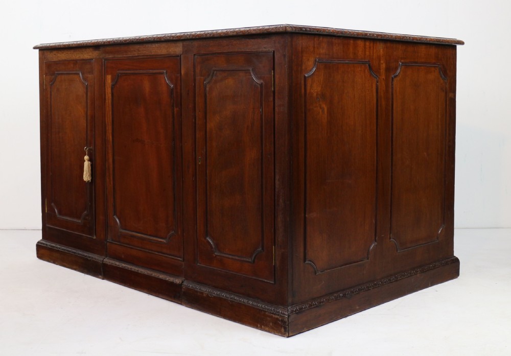 A dark mahogany kneehole library desk featuring multiple drawers with brass drop handles and panelled sides. View VI
