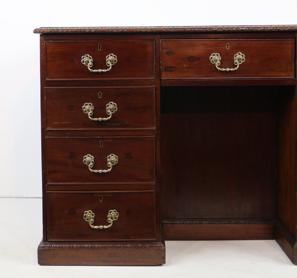 A dark mahogany kneehole library desk featuring multiple drawers with brass drop handles and panelled sides. View IX