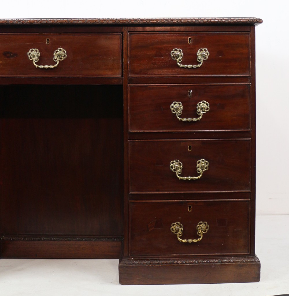 A dark mahogany kneehole library desk featuring multiple drawers with brass drop handles and panelled sides. View X