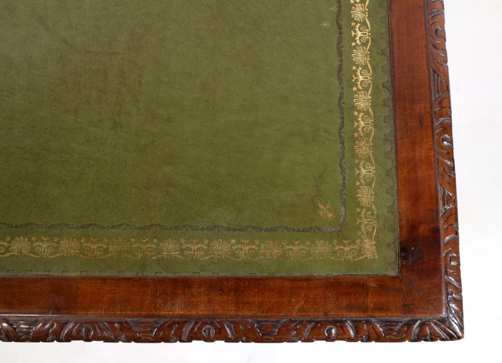 A dark mahogany kneehole library desk featuring multiple drawers with brass drop handles and panelled sides. View XVI