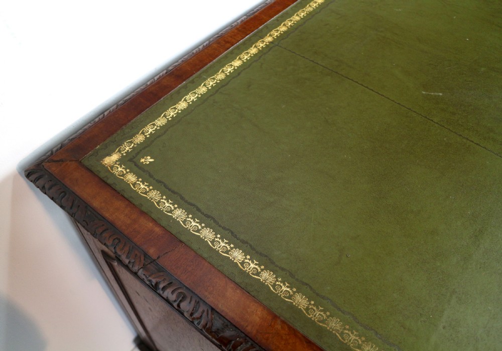 A dark mahogany kneehole library desk featuring multiple drawers with brass drop handles and panelled sides. View XVII