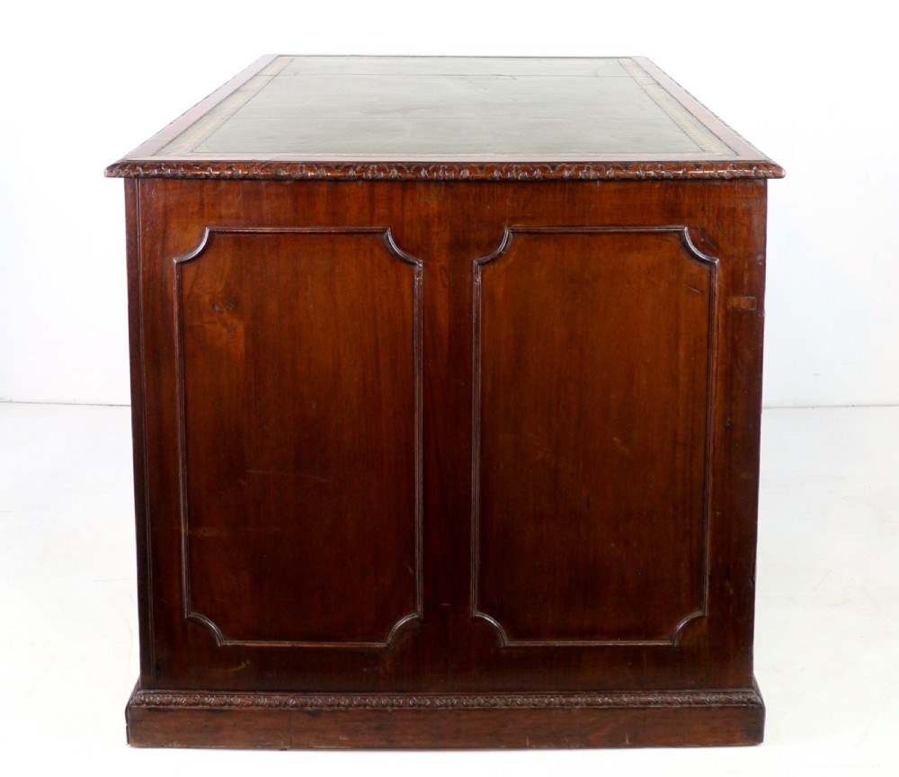 A dark mahogany kneehole library desk featuring multiple drawers with brass drop handles and panelled sides. View XIX