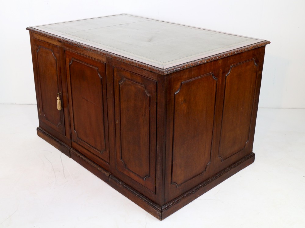 A dark mahogany kneehole library desk featuring multiple drawers with brass drop handles and panelled sides. View XX