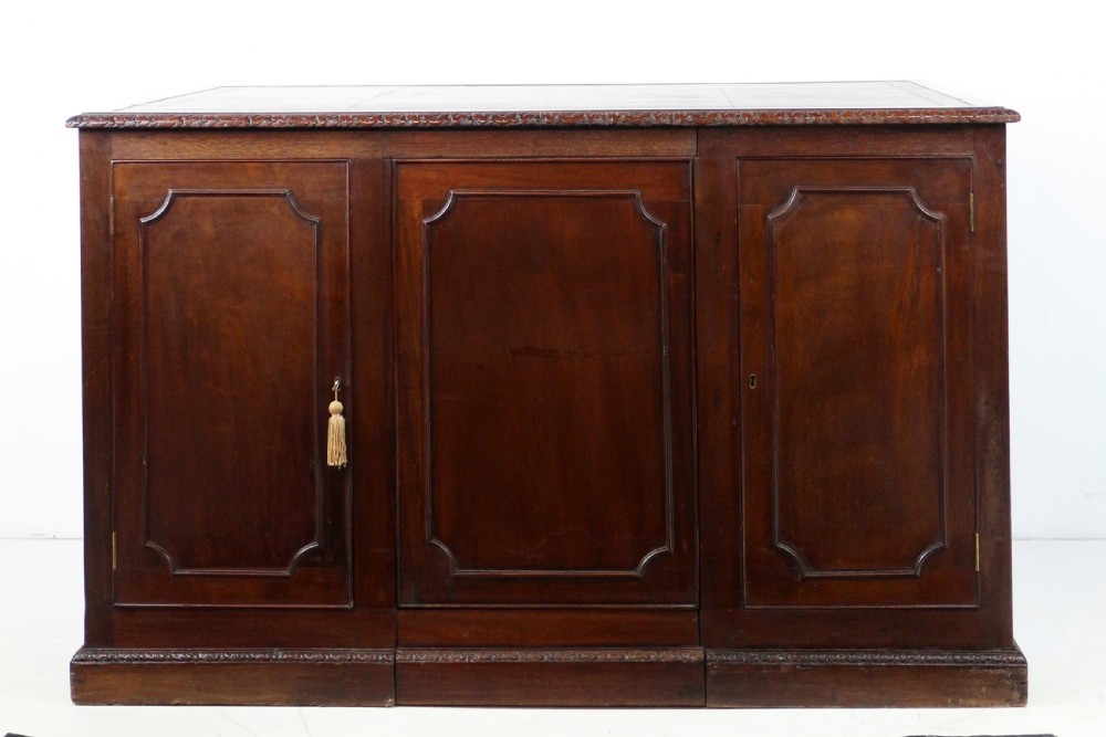 A dark mahogany kneehole library desk featuring multiple drawers with brass drop handles and panelled sides. View XXII