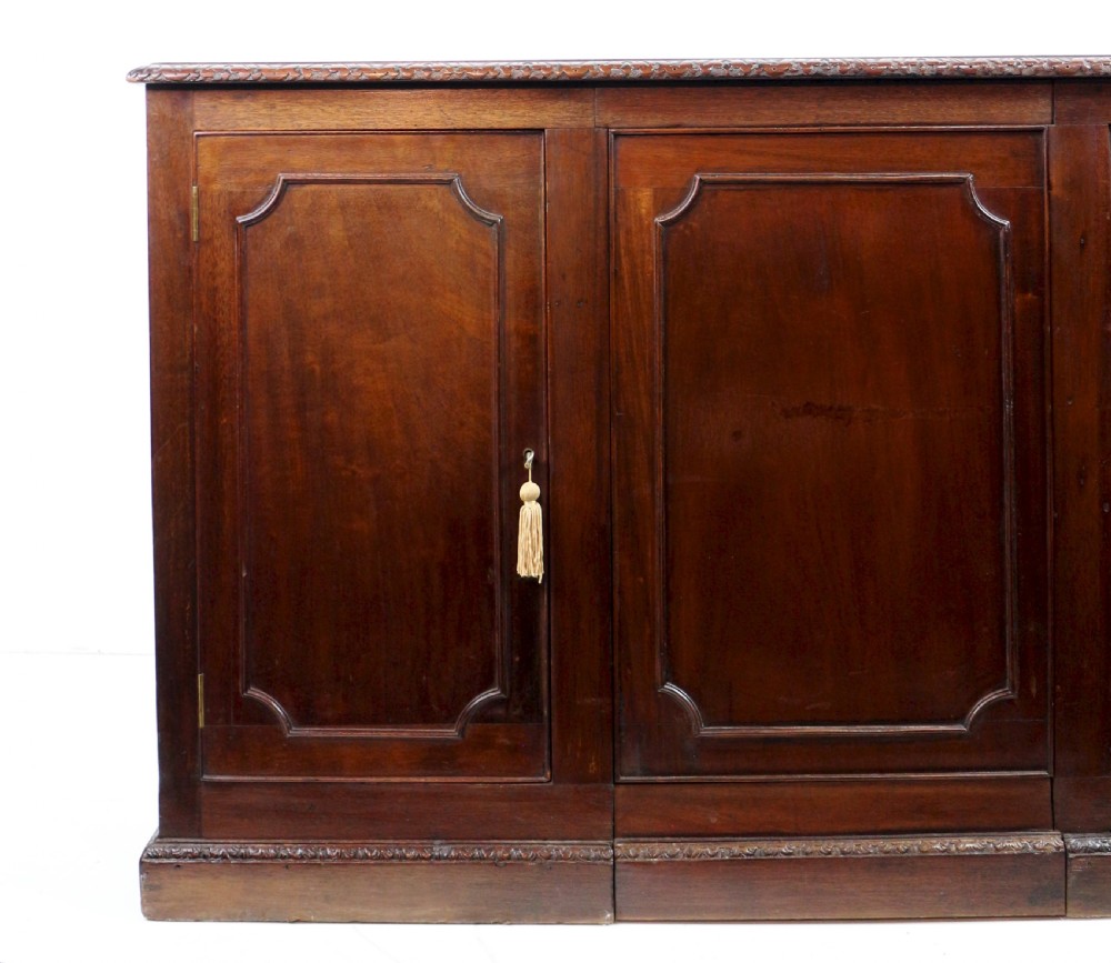 A dark mahogany kneehole library desk featuring multiple drawers with brass drop handles and panelled sides. View XXIII