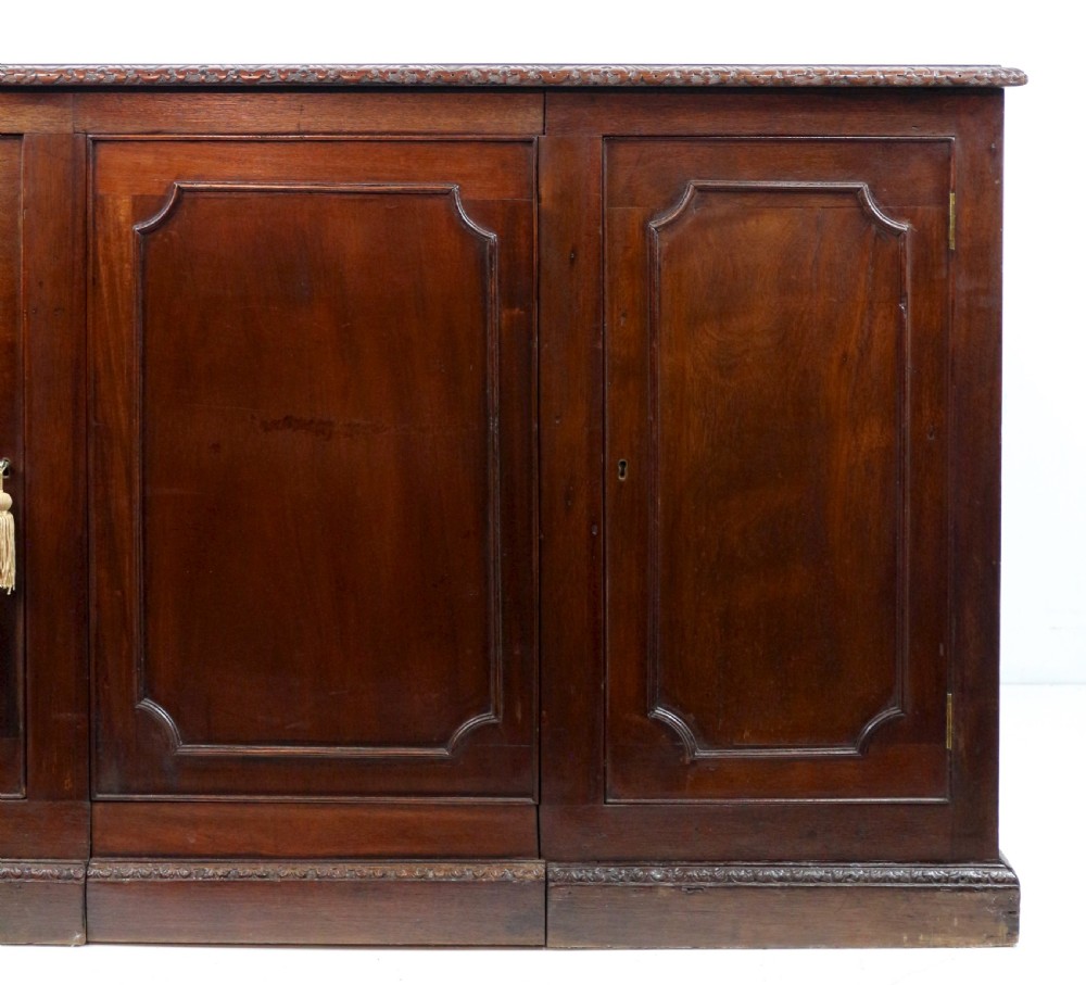 A dark mahogany kneehole library desk featuring multiple drawers with brass drop handles and panelled sides. View XXIV