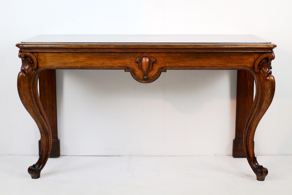 An antique William IV oak hall table featuring carved cabriole front legs and a central carved apron accent. View II