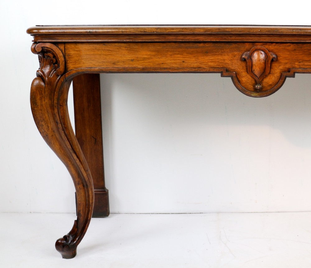 An antique William IV oak hall table featuring carved cabriole front legs and a central carved apron accent. View III