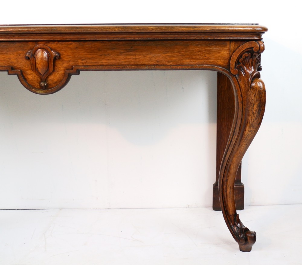 An antique William IV oak hall table featuring carved cabriole front legs and a central carved apron accent. View VI