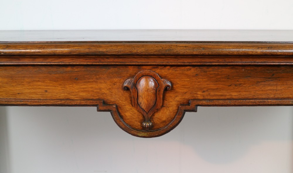 An antique William IV oak hall table featuring carved cabriole front legs and a central carved apron accent. View VII
