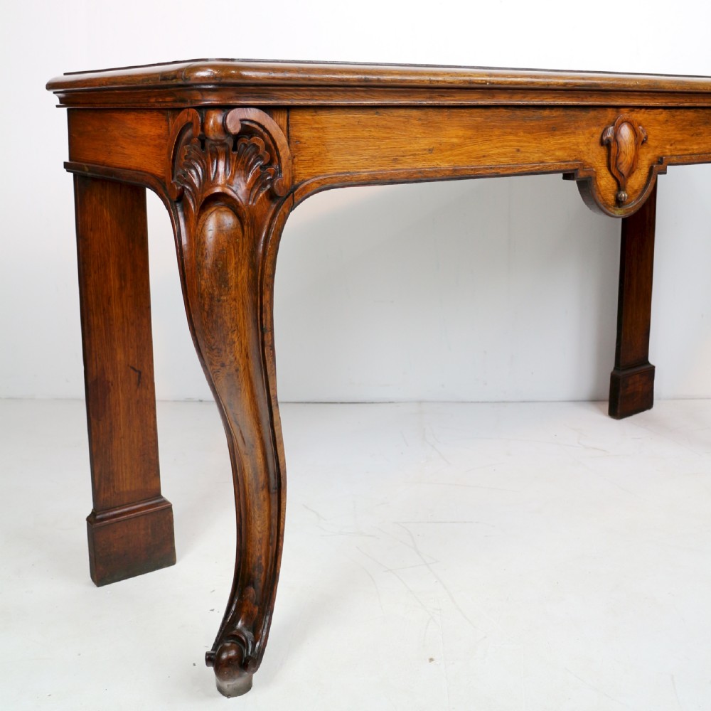 An antique William IV oak hall table featuring carved cabriole front legs and a central carved apron accent. View VIII