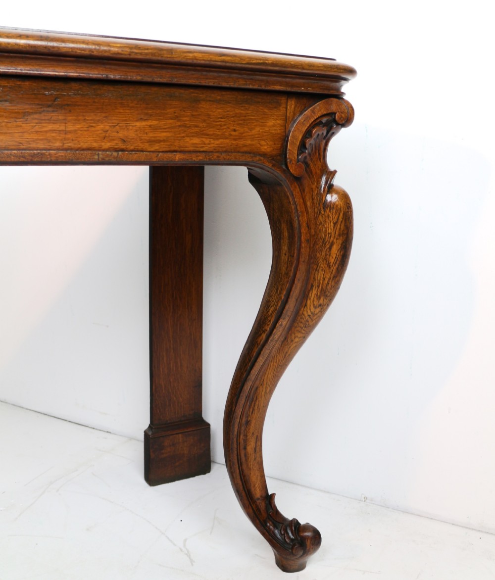 An antique William IV oak hall table featuring carved cabriole front legs and a central carved apron accent. View IX