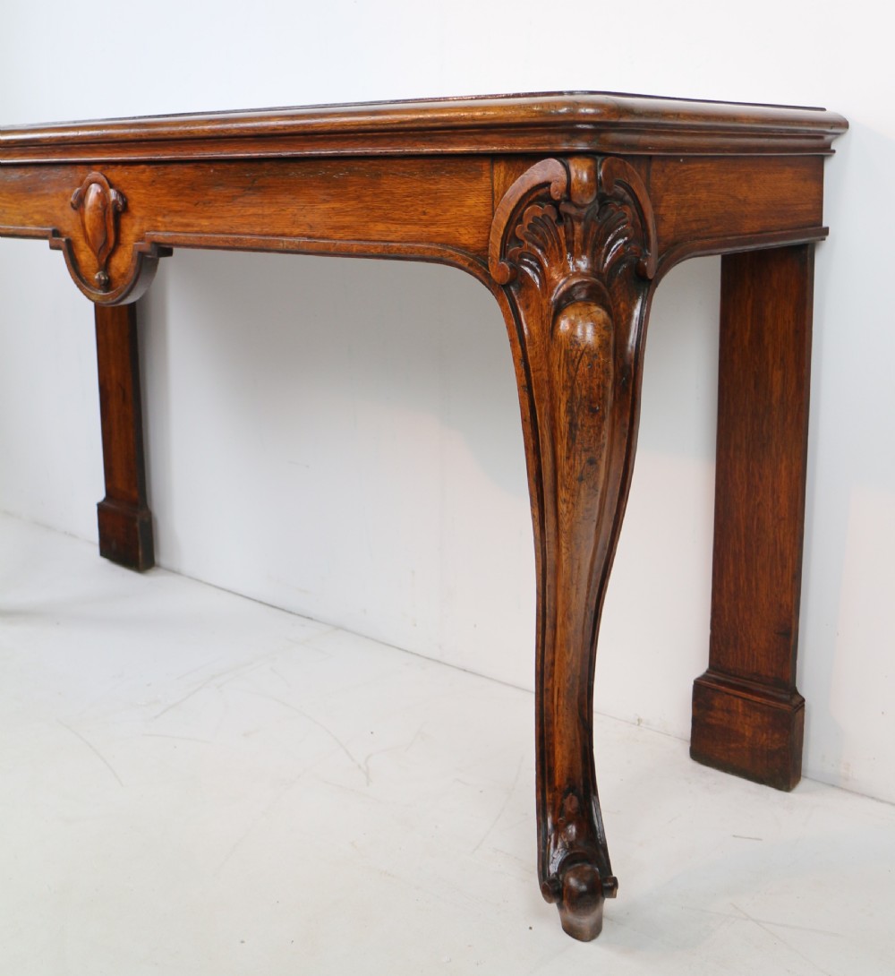 An antique William IV oak hall table featuring carved cabriole front legs and a central carved apron accent. View X
