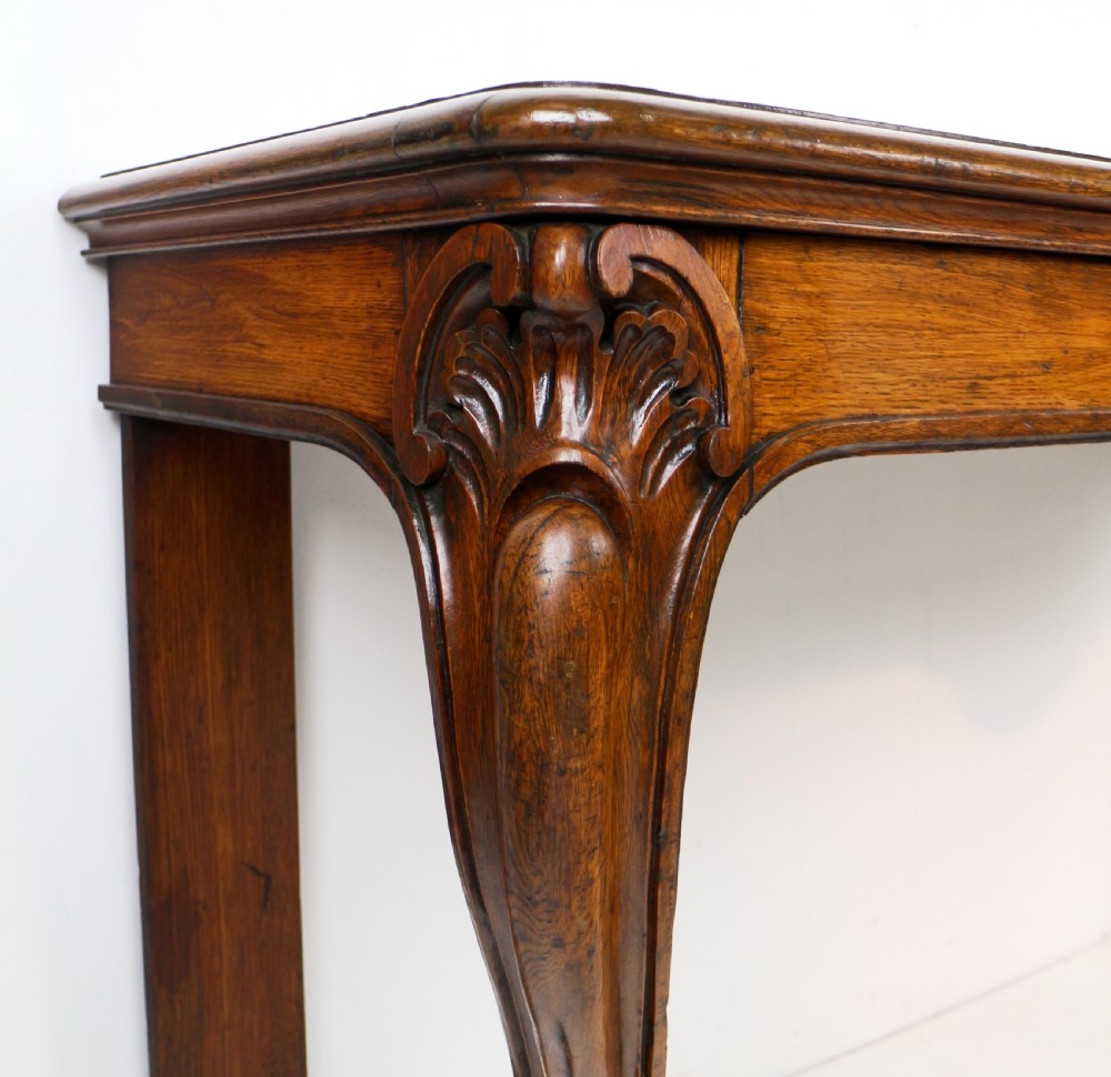 An antique William IV oak hall table featuring carved cabriole front legs and a central carved apron accent. View XI