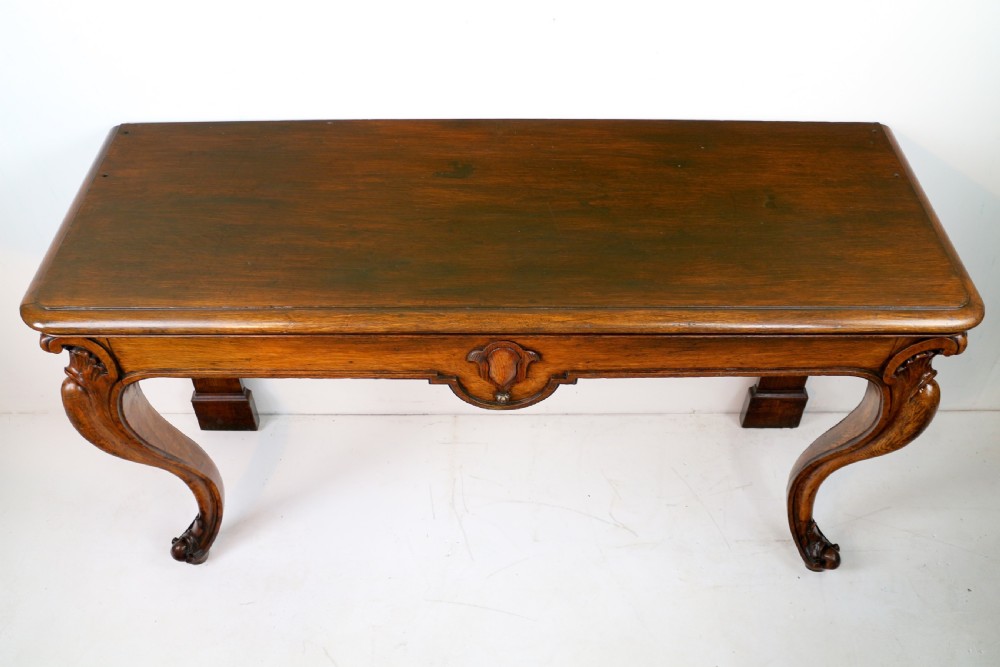 An antique William IV oak hall table featuring carved cabriole front legs and a central carved apron accent. View XVII