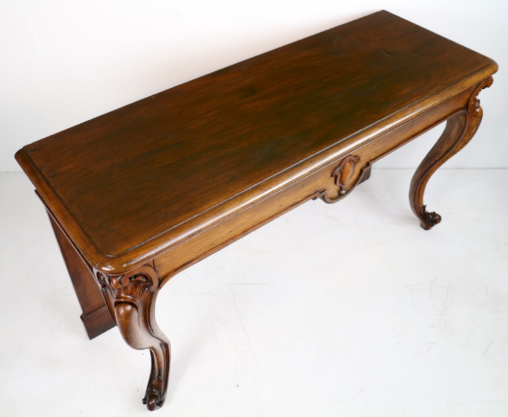 An antique William IV oak hall table featuring carved cabriole front legs and a central carved apron accent. View XVIII
