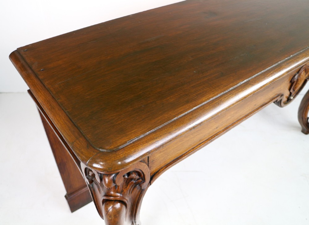 An antique William IV oak hall table featuring carved cabriole front legs and a central carved apron accent. View XIX
