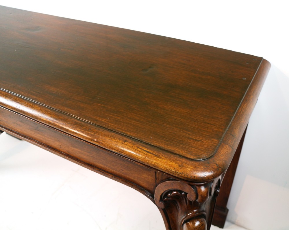 An antique William IV oak hall table featuring carved cabriole front legs and a central carved apron accent. View XXII