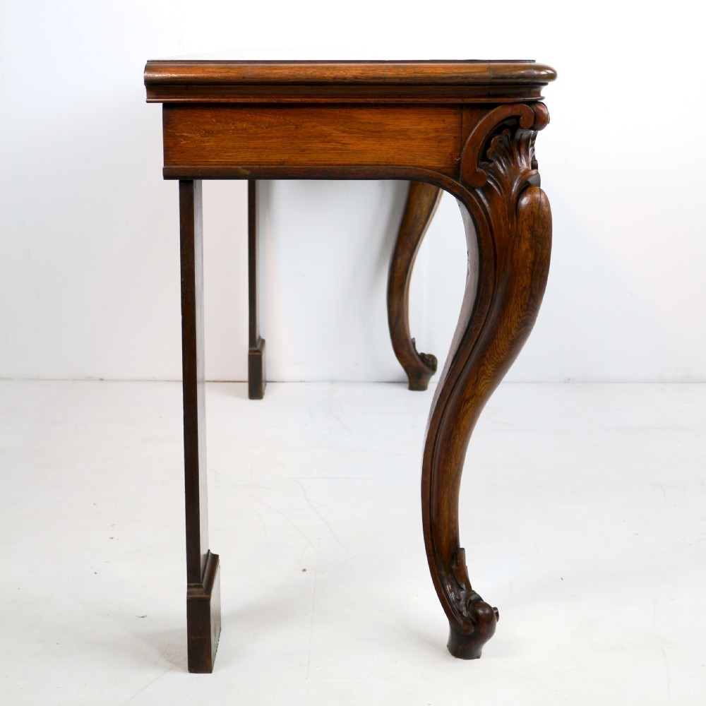An antique William IV oak hall table featuring carved cabriole front legs and a central carved apron accent. View XXIV