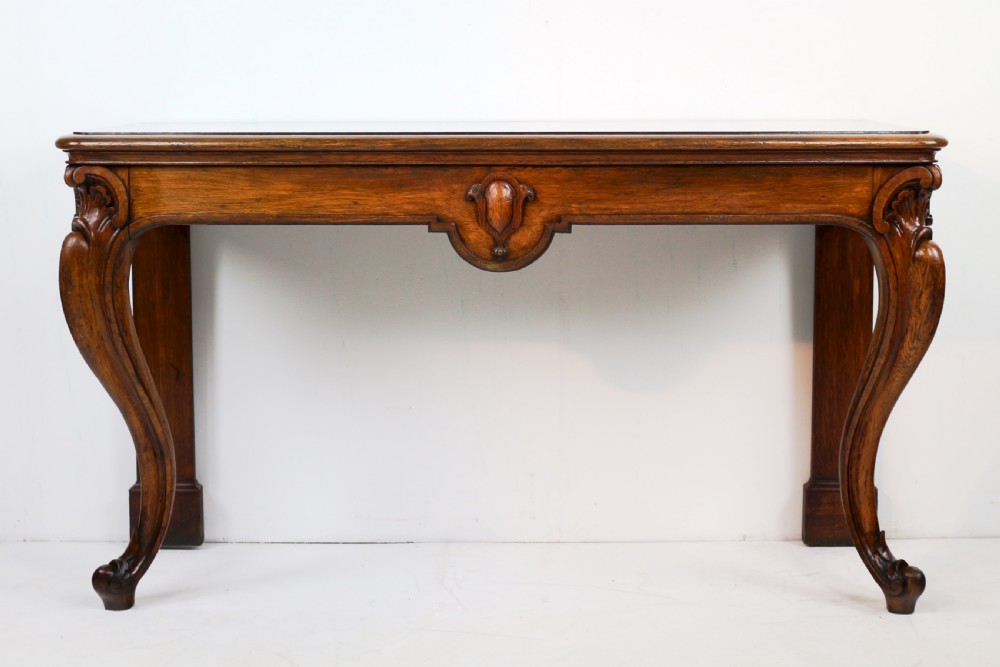 An antique William IV oak hall table featuring carved cabriole front legs and a central carved apron accent. View XXV
