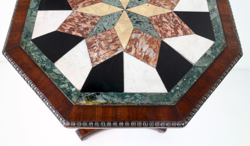 An octagonal Regency mahogany side table featuring a geometric star-patterned specimen marble top supported by a reeded column and triform base. View IX