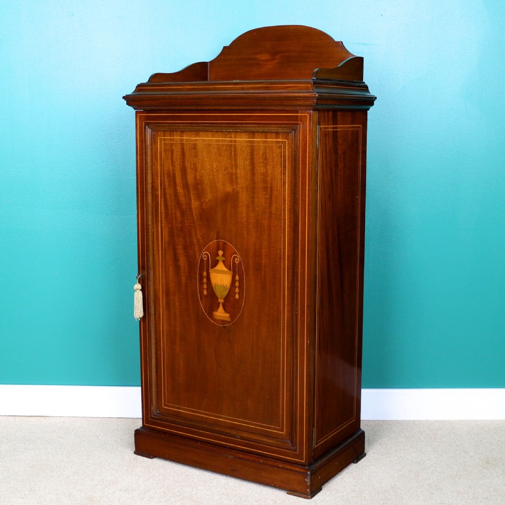 A Victorian mahogany music side cabinet featuring satinwood stringing, a central urn marquetry medallion on the door, and a shaped gallery top.