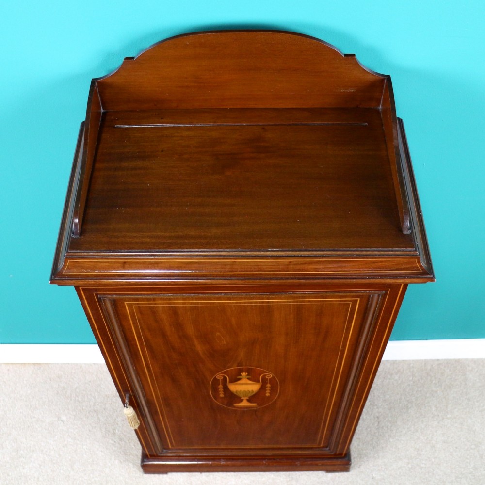 A Victorian mahogany music side cabinet featuring satinwood stringing, a central urn marquetry medallion on the door, and a shaped gallery top. View IV