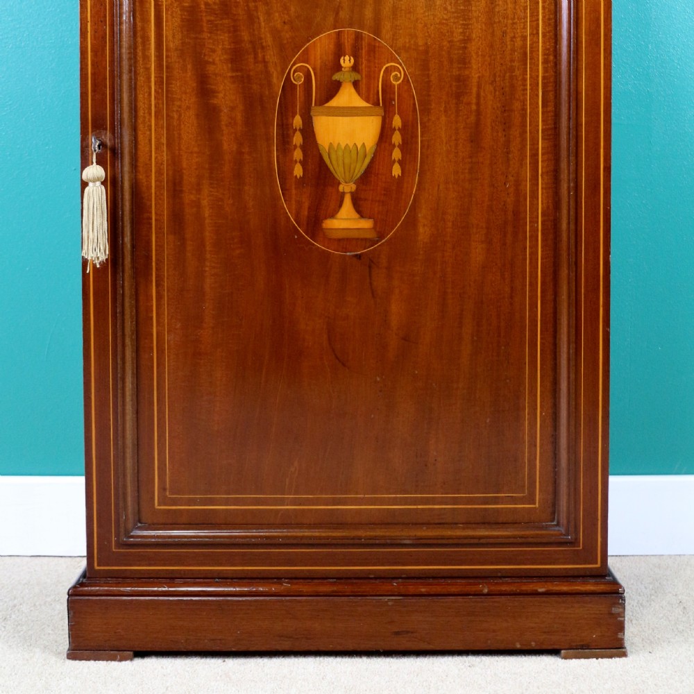 A Victorian mahogany music side cabinet featuring satinwood stringing, a central urn marquetry medallion on the door, and a shaped gallery top. View VII