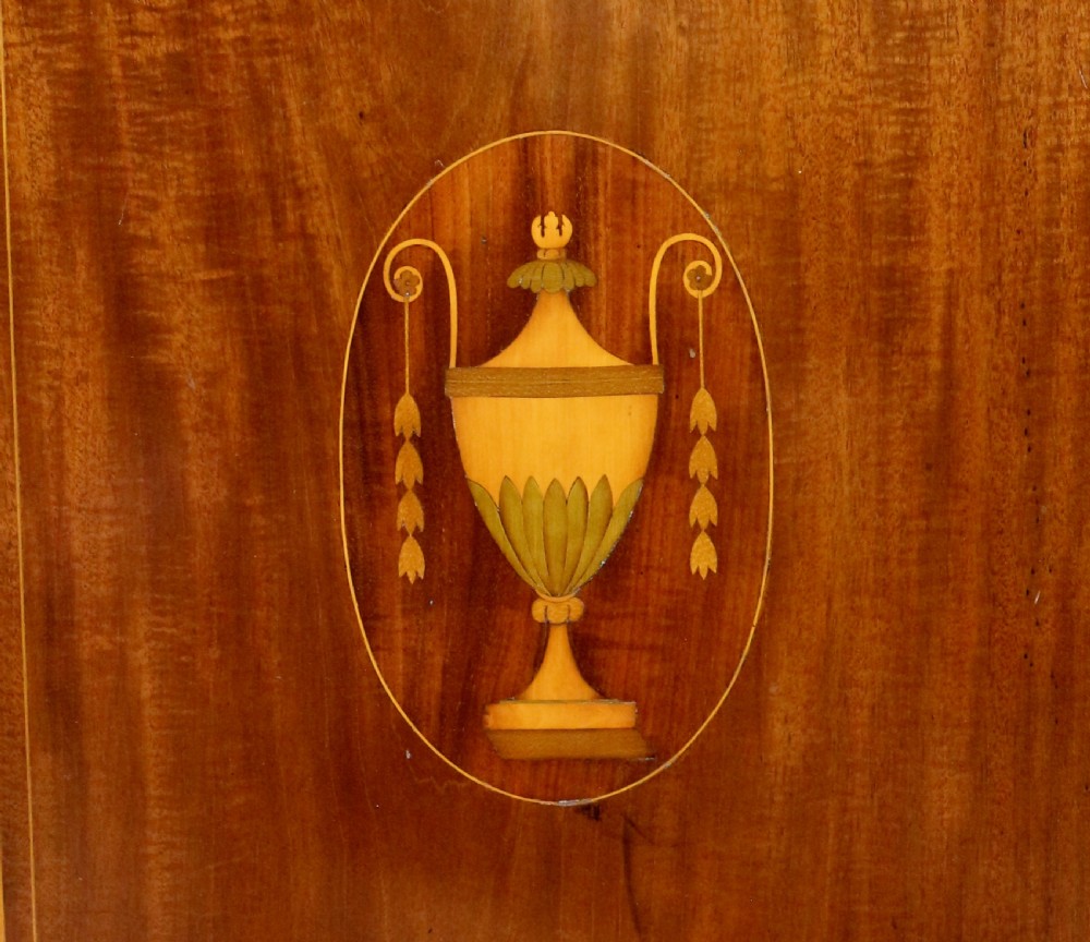A Victorian mahogany music side cabinet featuring satinwood stringing, a central urn marquetry medallion on the door, and a shaped gallery top. View IX