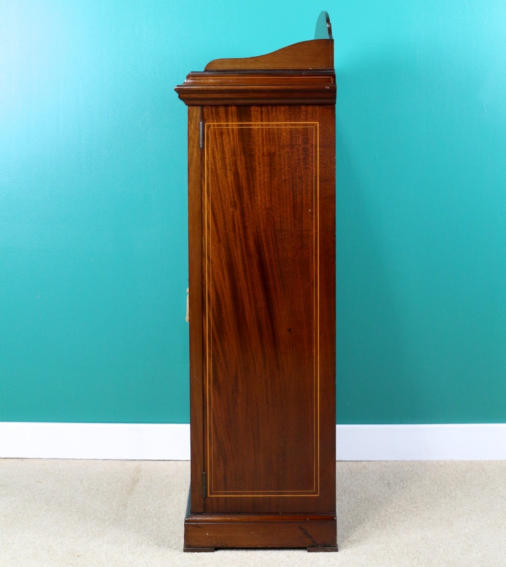 A Victorian mahogany music side cabinet featuring satinwood stringing, a central urn marquetry medallion on the door, and a shaped gallery top. View XIV
