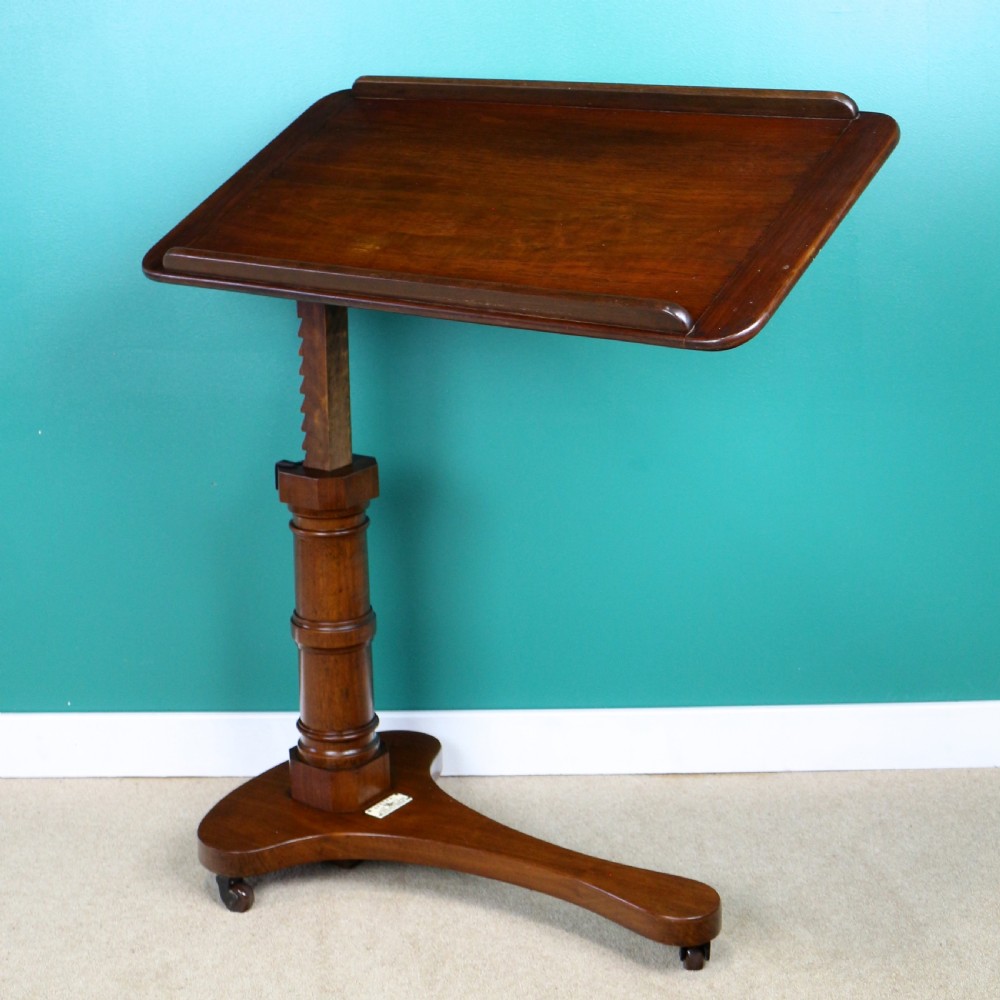 A Victorian mahogany adjustable reading table featuring a ratchet height mechanism, tilted top ledge, turned pedestal, and curved base on castors. View III