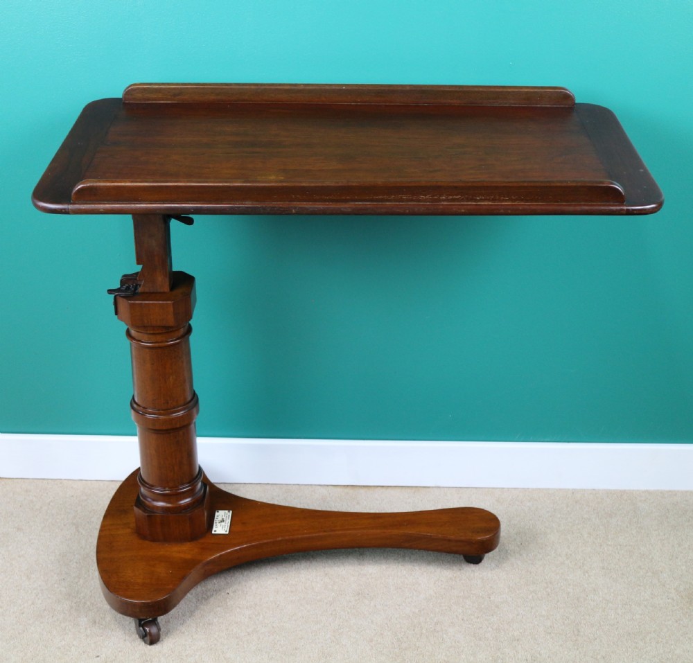 A Victorian mahogany adjustable reading table featuring a ratchet height mechanism, tilted top ledge, turned pedestal, and curved base on castors. View VIII