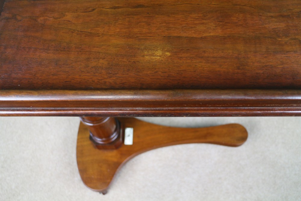 A Victorian mahogany adjustable reading table featuring a ratchet height mechanism, tilted top ledge, turned pedestal, and curved base on castors. View XI